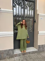 Pantalón de lanilla color negro, de corte recto y tiro alto, con diseño holgado y fluido.