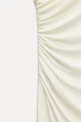 Vestido midi negro sin mangas, con cuello subido y detalle de drapeado en el delantero. Cierre en la espalda con cremallera oculta.