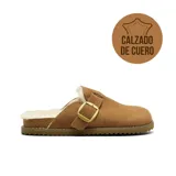 Zueco de cuero gamuzado color tostado, con interior forrado en piel sintética, hebilla metálica dorada ajustable en el empeine y suela dentada.