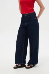 Pantalón jean azul oscuro, de tiro alto y corte ancho, con bolsillos y pespuntes en tono contrastante.