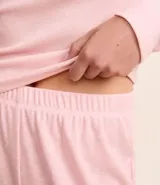 Pijama femenino largo de ribana color beige claro, compuesto por una blusa de manga larga con cuello redondo y detalle de botones frontales, y un pantalón largo de corte recto.