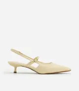 Zapato de tacón color crema, con punta fina, tira delantera y tira trasera con hebilla.