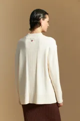 Polera de cuello alto confeccionada en tejido de punto negro, con diseño de textura acanalada en cuello, puños y ruedo, y trama vertical en mangas y espalda.