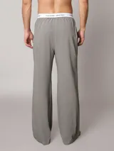 Pantalón de pijama Calvin Klein de corte regular y pierna recta, color gris, confeccionado en punto de algodón suave. Cuenta con bolsillos en las costuras laterales y cinturilla elástica distintiva de la marca.