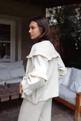 Campera de jean blanca con volados en el frente y las mangas, confeccionada en algodón y lino.