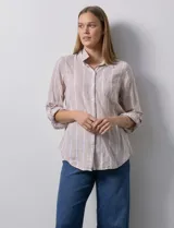 Camisa de lino marca Dash, color beige con rayas verticales blancas, cuello con solapa, cierre frontal de botones, bolsillo aplicado en el pecho y mangas largas con sistema para arremangar mediante presilla y botón.