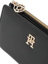Billetera plegable color negro de Tommy Hilfiger, con acabado granulado, cierre de botón a presión, bolsillo exterior con cremallera e insignia metálica del monograma TH en la parte delantera.