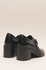 Zapato de cuero vacuno color borgoña con acabado charol, taco cuadrado de 4 cm y hebilla lateral.