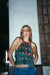 Top de gamuza verde inglés, con diseño de paneles unidos por remaches metálicos plateados, escote halter y corte cropped.