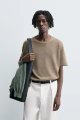 Camiseta de punto ligero color marrón topo, con cuello redondo y manga corta ancha. Presenta una textura acanalada o de estructura fina.