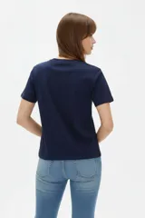 Remera de manga corta de algodón en color blanco, con cuello redondo y diseño holgado. Cuenta con un estampado frontal central con detalles metalizados estilo foil.
