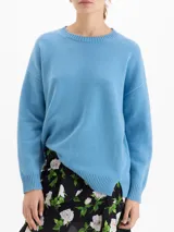 Sweater de punto con textura suave, de silueta relajada y largo por debajo de la cadera. Presenta cuello redondo, mangas largas y costuras laterales desplazadas hacia el frente.
