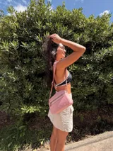 Bandolera de diseño moderno y funcional, confeccionada en nylon color marrón claro. Cuenta con múltiples compartimentos con cierre metálico, herrajes plateados y una correa ancha ajustable con detalle de marca.