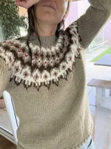 Sweater tejido a mano de corte clásico, color gris con diseño de guarda nórdica en el canesú en tonos blanco, marrón y detalles en rojo.