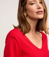 Blusa de punto color rojo con escote en V, mangas largas y hombreras.