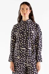 Camisa de manga larga fluida con estampado de lunares y pequeños peces, cuello camisero y cierre frontal con botones ocultos.