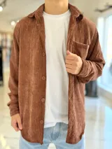 Sobrecamisa de pana color marrón chocolate, de manga larga, con cuello camisero, cierre frontal con botones y un bolsillo aplicado en el pecho.