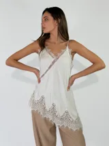 Top de viscosa color blanco con tirantes finos, escote en V y detalles de encaje asimétrico en el escote y el ruedo.