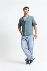 Camisa de manga corta color crema con textura, cuello clásico y calce regular.