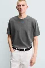 Camiseta regular fit de color beige, confeccionada en tejido de algodón compacto, con cuello redondo y manga corta.