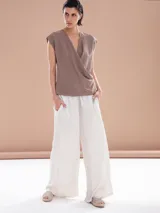 Pantalón palazzo blanco con cintura alta y cordón ajustable.