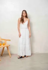 Vestido largo blanco de tirantes finos, con escote en V y detalles de inserciones de encaje broderie en la cintura y en la falda escalonada.