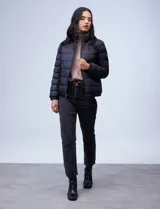 Campera de plumas reversible marca Michael Kors. Un lado es liso y el otro estampado con el logo de la marca. Tiene abertura central con cierre metálico, bolsillos delanteros y avíos metálicos con el logo. Incluye bolsa autoportante.