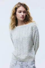 Buzo gris de punto pointelle con lana, escote bote off-the-shoulder y mangas largas. Cuenta con remates acanalados en el escote, puños y dobladillo.