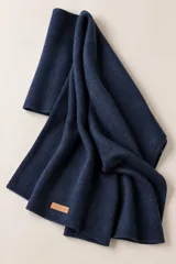 Bufandón de lana lambswool color azul marino, suave, liviano y abrigado, con etiqueta de cuero sintético con la marca Magnolia.