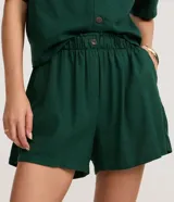 Short femenino de viscolino color blanco, modelo runner evasê, con cintura elástica, botón frontal y bolsillos laterales.