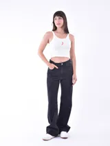 Musculosa corta de tejido acanalado color verde menta, con escote redondo y tirantes anchos. Presenta un pequeño bordado frontal con forma de flor o mariposa en tonos rosados.