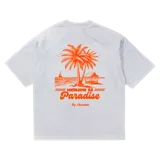 Remera blanca de algodón con estampa de palmeras, cabaña y velero en color naranja.