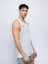 Musculosa deportiva Umbro color gris claro, con cuello redondo y logo Umbro en color rojo en el pecho. Presenta tejido de malla en la espalda para mayor ventilación.