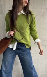 Sweater de punto color verde lima, de manga larga, con detalle de bordado en relieve con diseño floral en el frente.