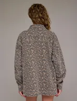 Chaqueta de jean oversize con estampado animal print, cuello solapa, abertura central con botones metálicos y bolsillos delanteros.