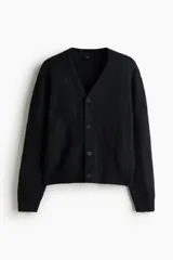 Cárdigan negro de punto peludo suave, con cuello en V pronunciado y cierre frontal de botones. Presenta remates acanalados en puños y bajo.
