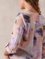 Blusa estampada de Zac & Rachel con cuello a la base, escote en V y botones. Tiene un bolsillo aplicado en la parte delantera, mangas largas regulables con presilla y botón, y terminación anudada opcional.