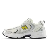 Championes New Balance modelo 530, de estilo retro inspirado en el running. Presentan una base de malla blanca con superposiciones en cuero sintético plateado y detalles en amarillo y azul oscuro. Incorporan tecnología de amortiguación ABZORB en la entresuela para mayor confort.