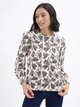 Remera de algodón con estampado botánico abstracto en color negro sobre fondo beige, de cuello redondo, mangas largas abullonadas y puños elásticos con detalle de frunce.