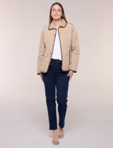 Campera matelaseada Michael Kors, de color beige con ribetes de ecocuero marrón. Cuenta con cuello con solapa, cierre frontal con broches metálicos, bolsillos laterales con cierre y mangas largas.