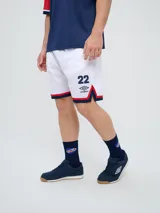 Short deportivo Umbro del Club Nacional de Football, modelo Match para hombre. Diseño en color azul marino con tejido de malla, detalles en blanco y rojo en los laterales y el escudo del club bordado.