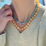 Collar de cuentas esféricas de jade amarillo de 10 mm, con nudos separadores en hilo naranja y cierre tipo toggle en acero con baño de oro.