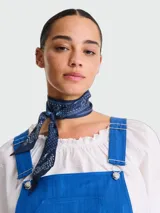 Pañuelo tipo bandana de seda en color azul marino con estampado clásico de motivos paisley y detalles florales en blanco.