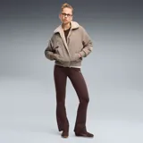 Calza deportiva Puma de corte flared (acampanado) en color marrón oscuro, con cintura alta y logo de la marca estampado en blanco en la pierna izquierda.
