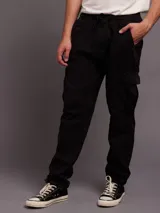 Pantalon tipo jogger cargo de color negro, con cintura elástica ajustable mediante cordón, bolsillos laterales tipo cargo con solapa y puños elásticos en los tobillos.