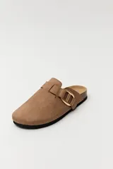 Zueco de estilo casual con capellada cerrada en material tipo gamuza color negro. Presenta una hebilla metálica decorativa en tono dorado sobre el empeine y una base anatómica con efecto corcho.