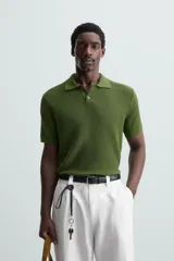 Polo de manga corta, corte regular fit, color verde oliva. Tejido de punto con textura acanalada vertical y cuello solapa con dos botones.