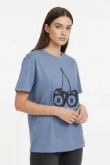 Remera de algodón color beige con estampado frontal de un corazón rosado que contiene un moño. Tiene cuello redondo y mangas cortas.