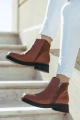 Bota corta de cuero negro con diseño minimalista, cierre lateral metálico y taco bajo cuadrado de 4 cm.