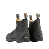 Botas tipo Chelsea Blundstone modelo 587, confeccionadas en cuero nobuck color negro rústico. Presentan puntera cuadrada, elásticos laterales negros y tiradores en la parte superior para facilitar el calce. Cuentan con suela de TPU de alta durabilidad y sistema de amortiguación en el talón.